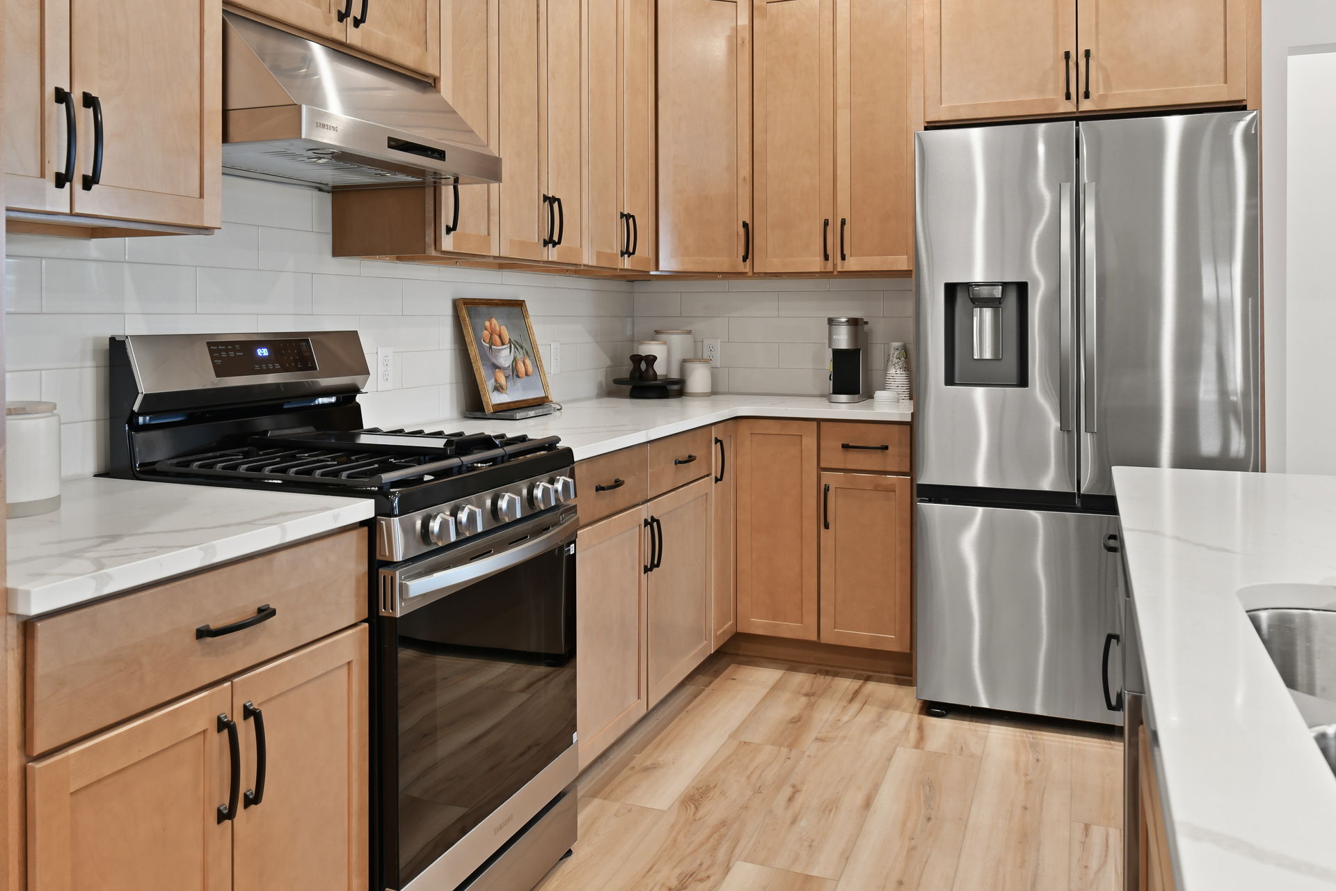 Modern kitchen with stainless steel appliances, wooden cabinets, and a sleek countertop.