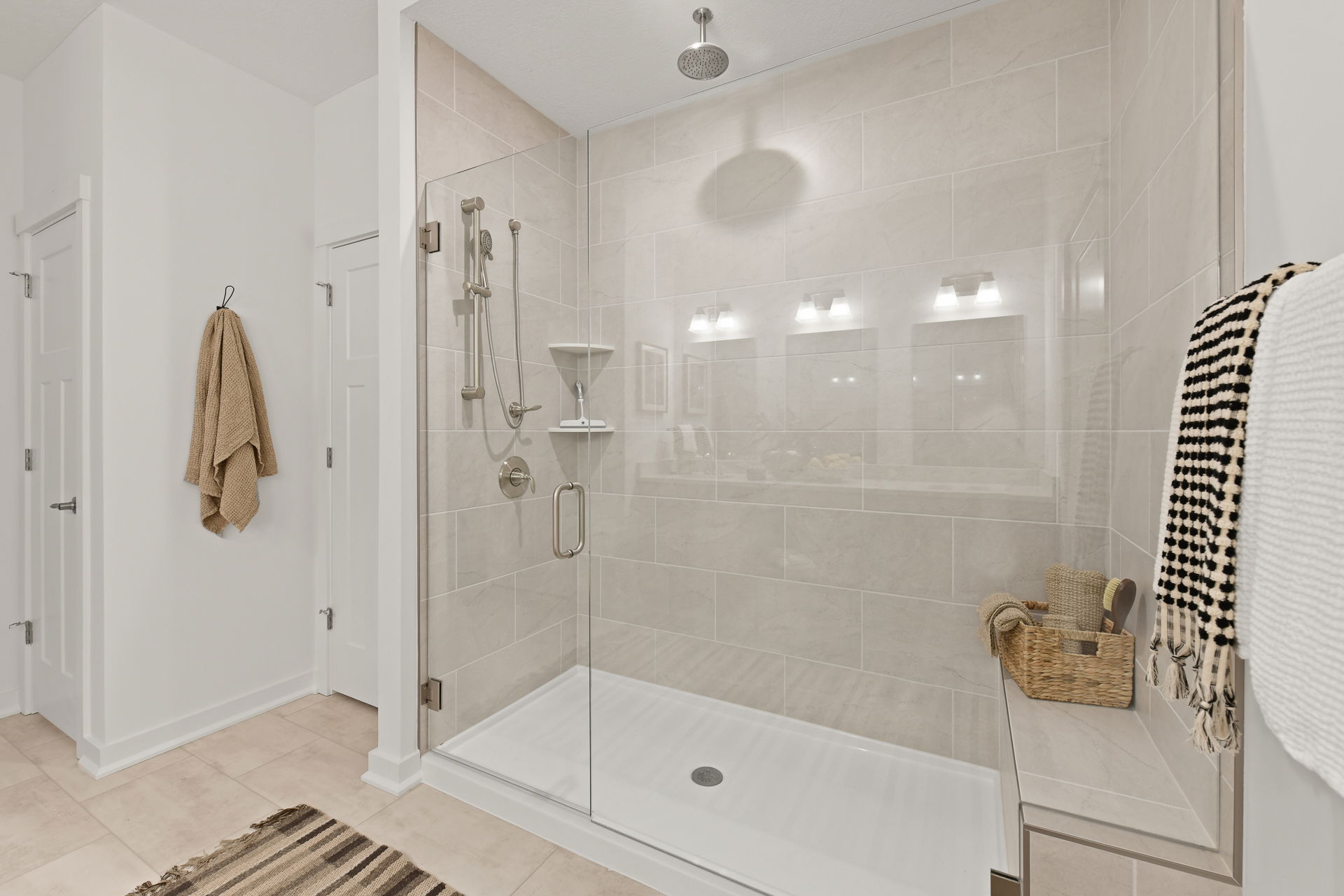 Modern bathroom with a spacious glass-enclosed shower featuring sleek fixtures and neutral tile design.