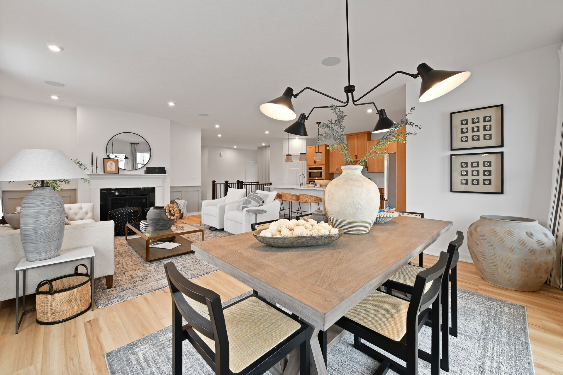 Modern open-concept living and dining area featuring elegant wooden furniture, neutral decor, and contemporary lighting.