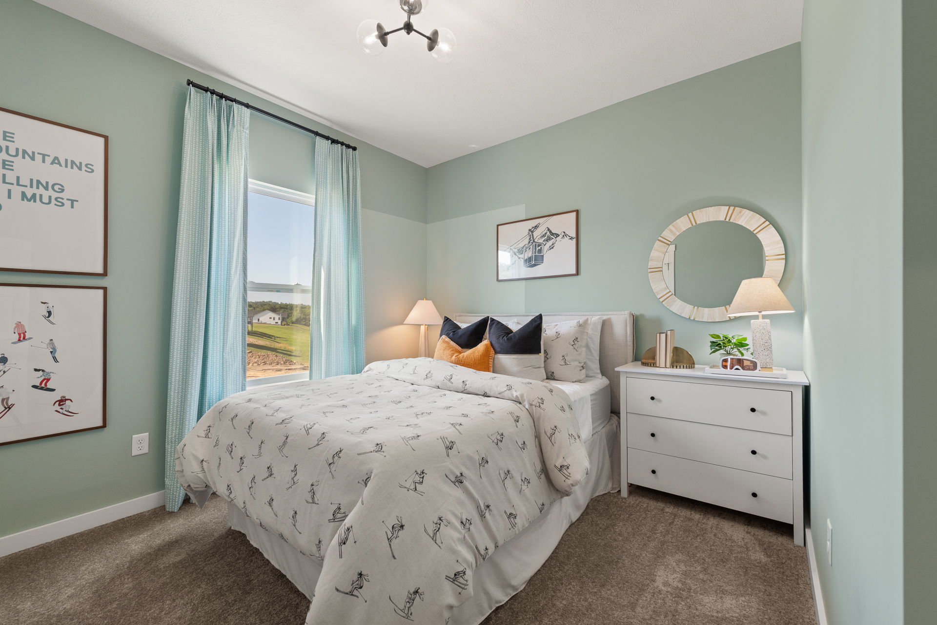 Cozy bedroom with ski-themed decor, soft green walls, and natural light streaming through the window.