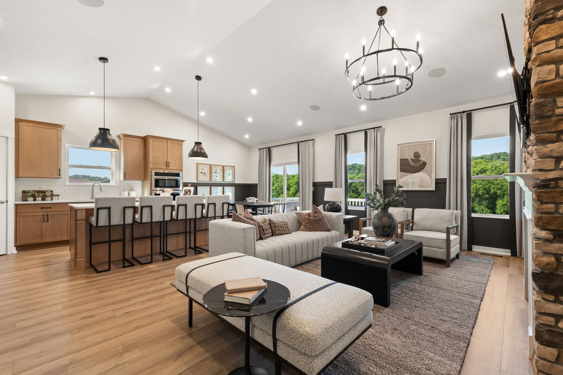 Modern open-concept living room and kitchen with sleek wood flooring, neutral tones, and stylish furnishings.