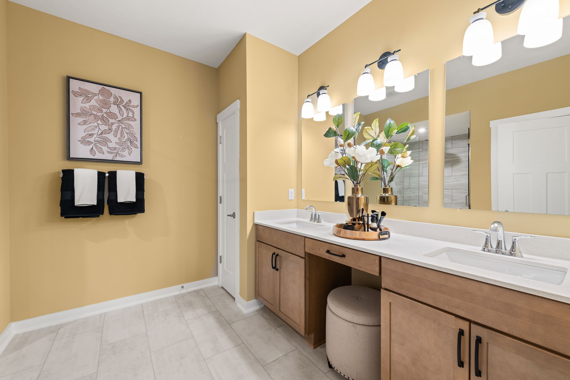 Modern bathroom interior with yellow walls, double vanity, decorative plant, and wall art for a stylish, inviting ambiance.
