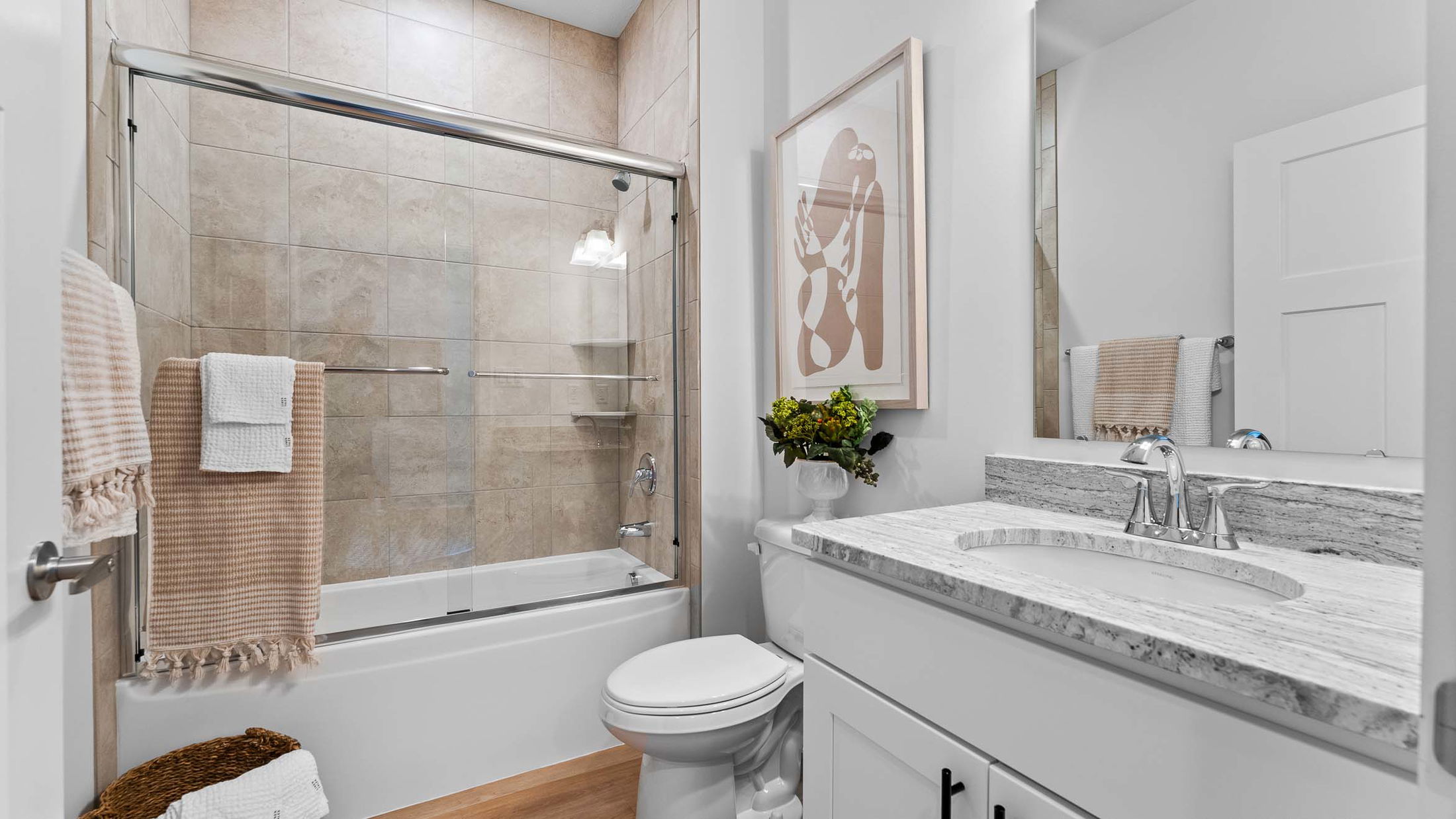 Modern bathroom with granite countertop, elegant shower, and stylish decor.