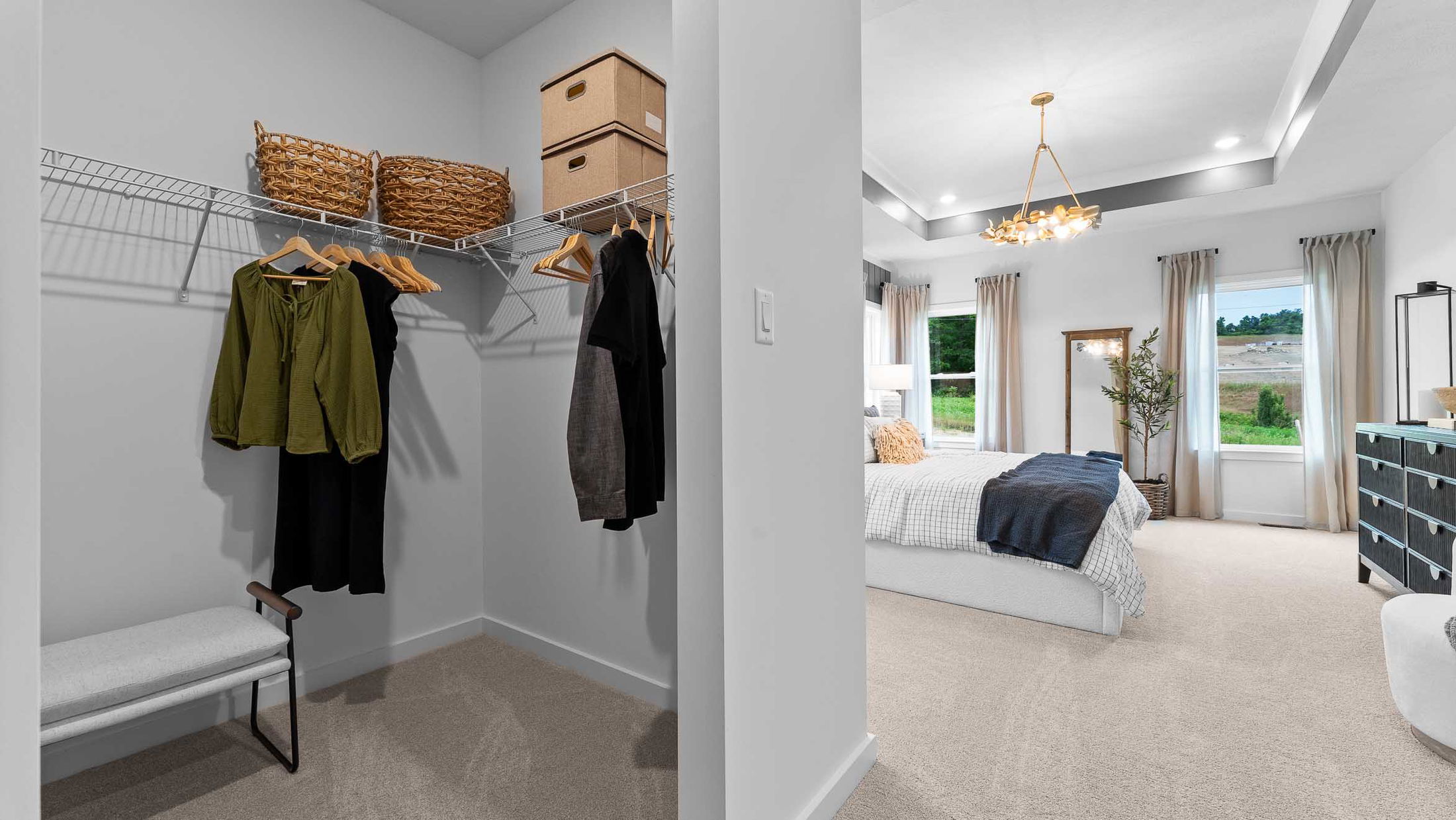 Walk-in closet with organized clothes and cozy bedroom view showcasing elegant decor and natural light.