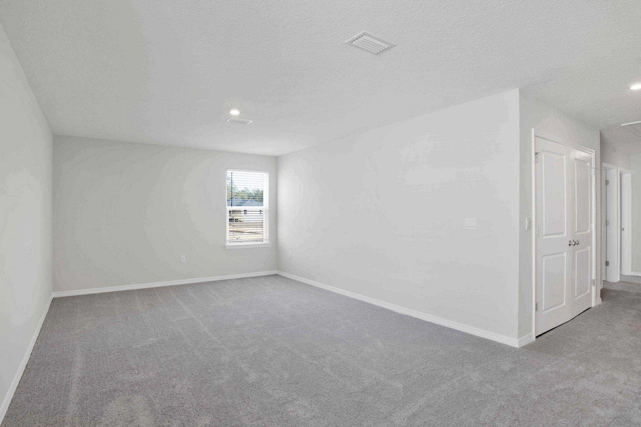 Empty room with gray carpet, white walls, and a single window.