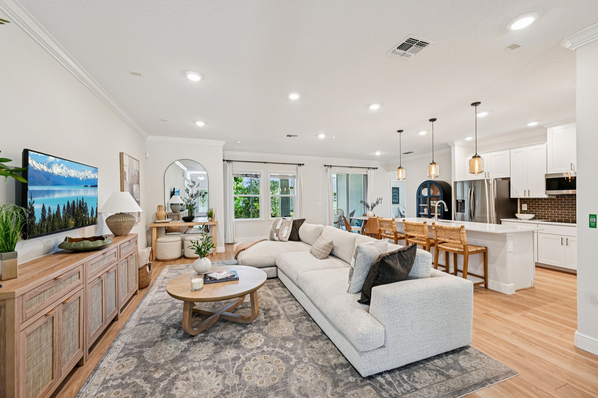 Modern open-concept living room and kitchen with cozy beige sectional sofa, stylish decor, and natural wood accents.