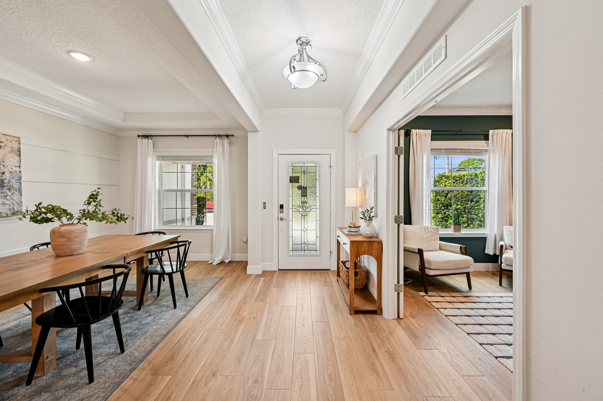 Modern open-plan living and dining area with wood flooring, natural light, and contemporary furniture.