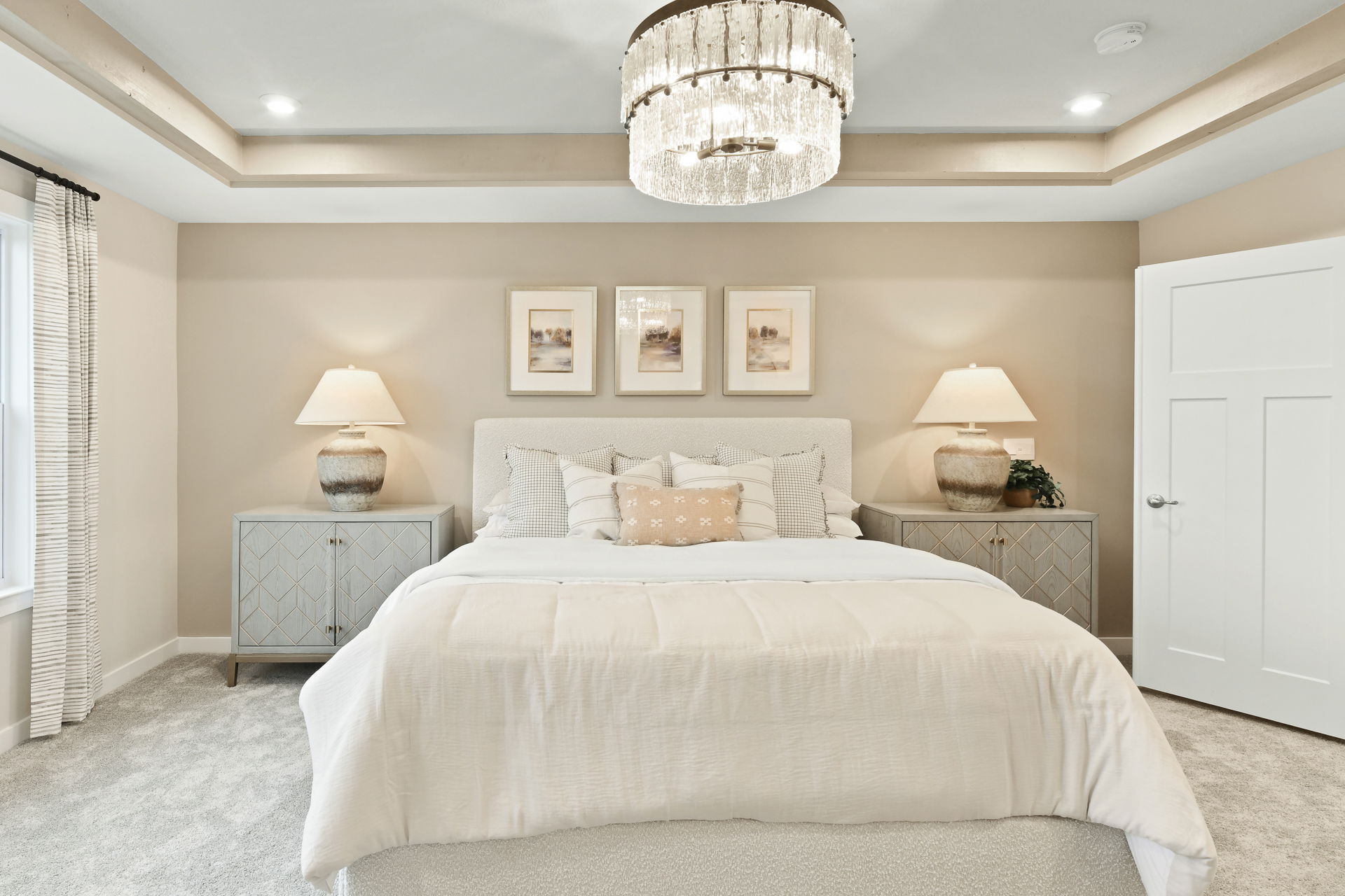 Elegant modern bedroom with a plush bed, stylish side tables, and a luxurious chandelier.
