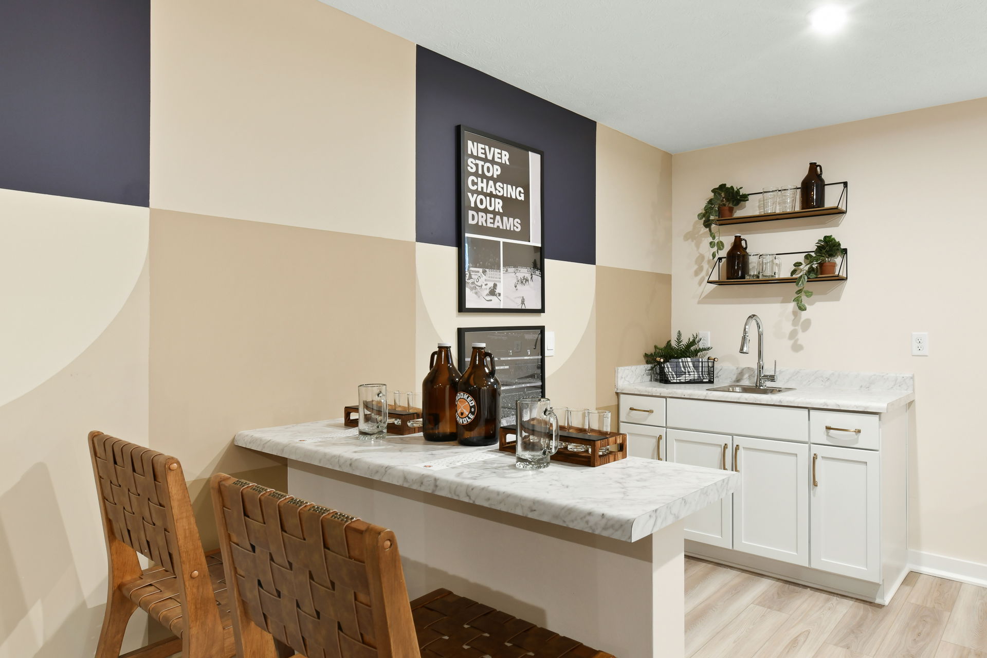 Cozy home bar area with marble countertops, woven chairs, decorative shelves, and a motivational 
