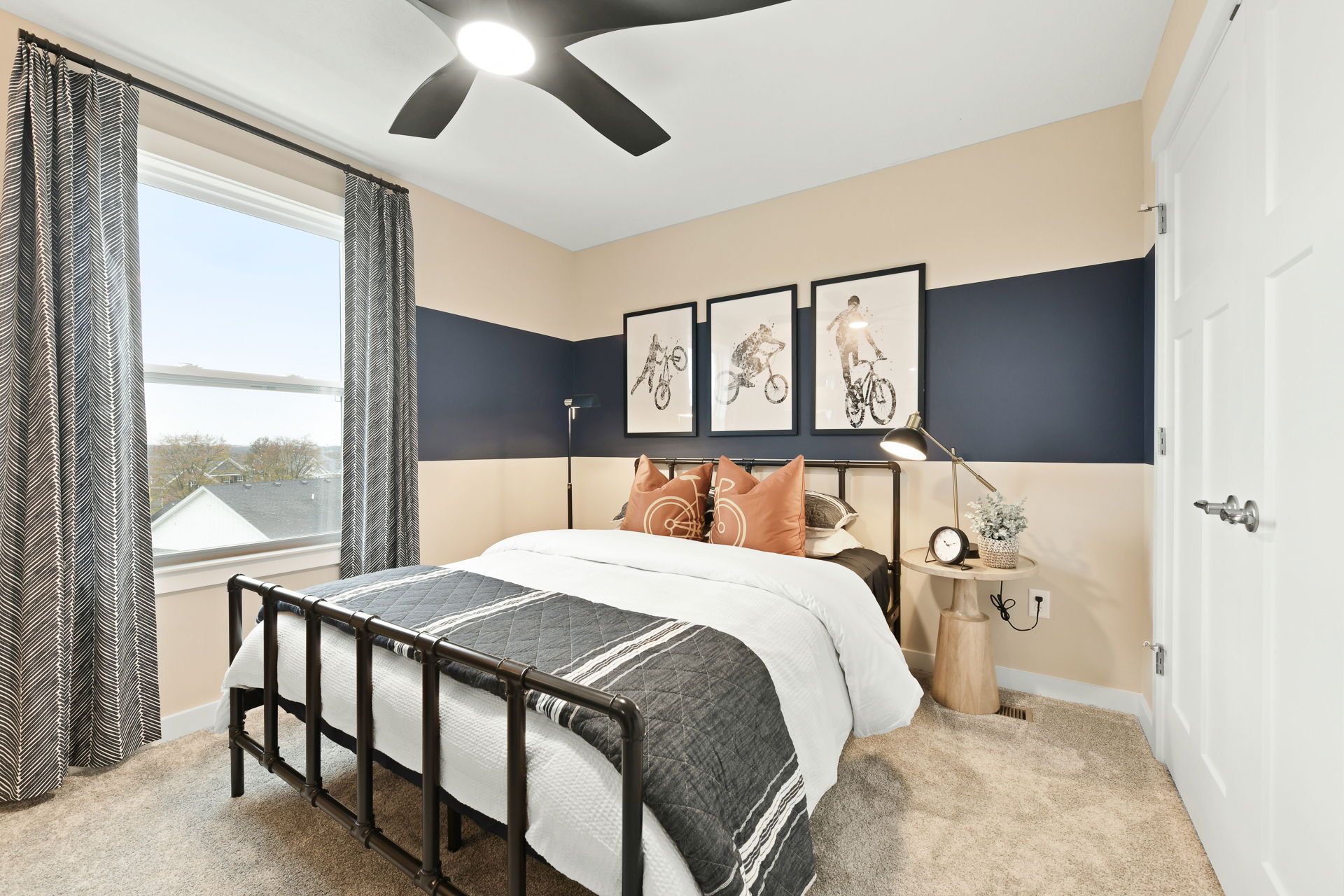 Modern bedroom with bike-themed wall art, stylish bedding, and contemporary decor.