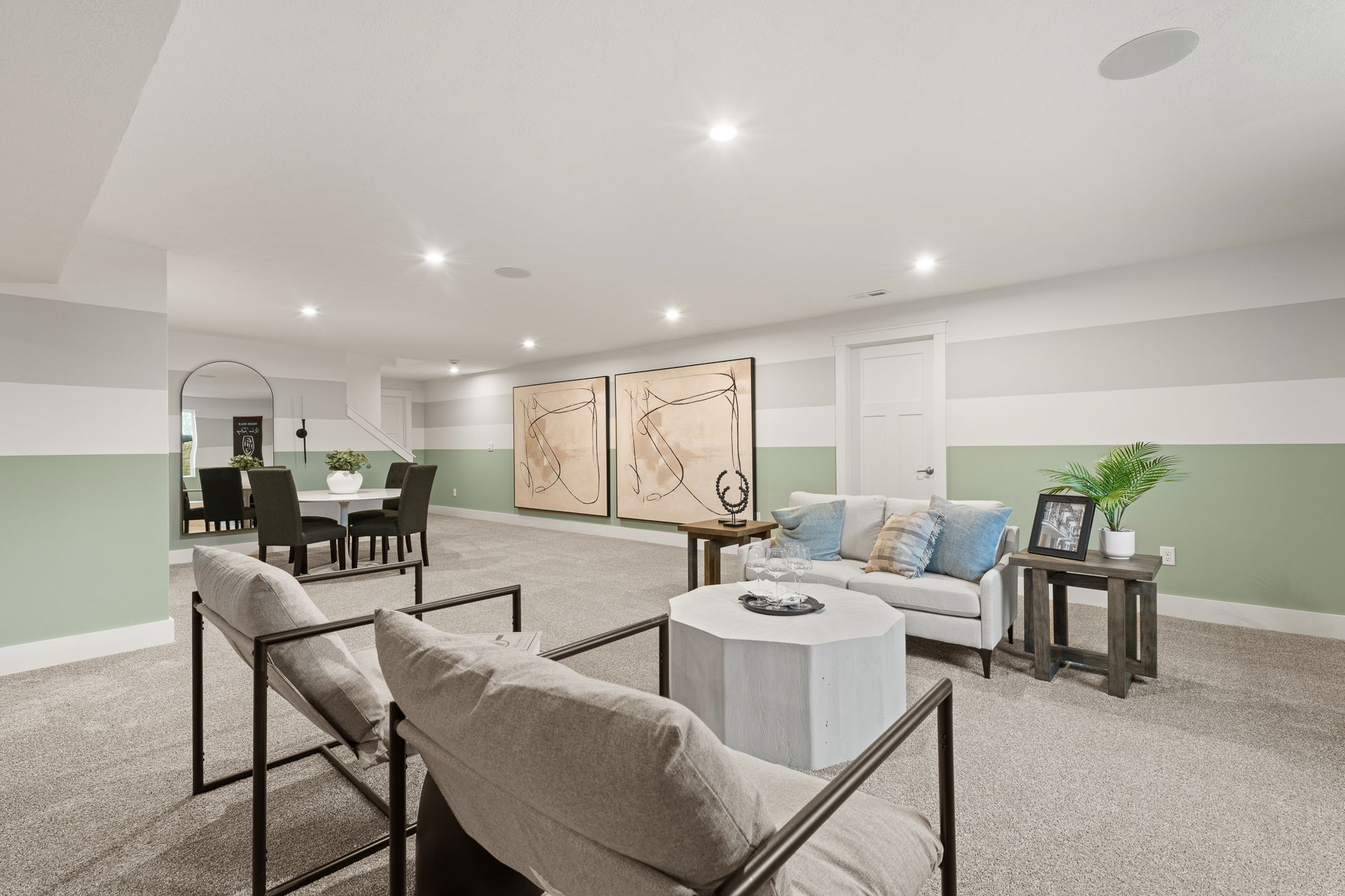 Modern finished basement with stylish seating area, contemporary artwork, and striped wall design.