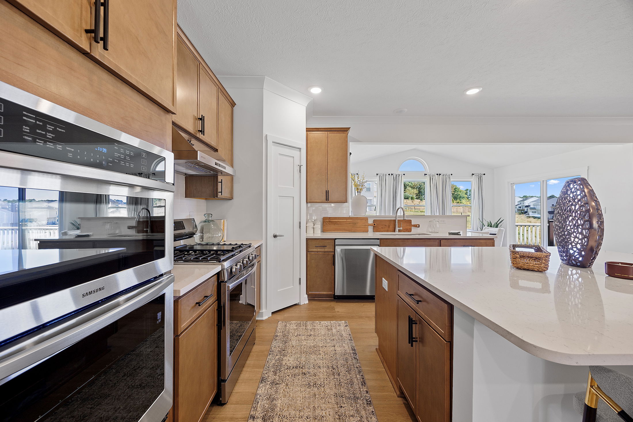 Modern kitchen with wooden cabinets, stainless steel appliances, and a spacious island counter.