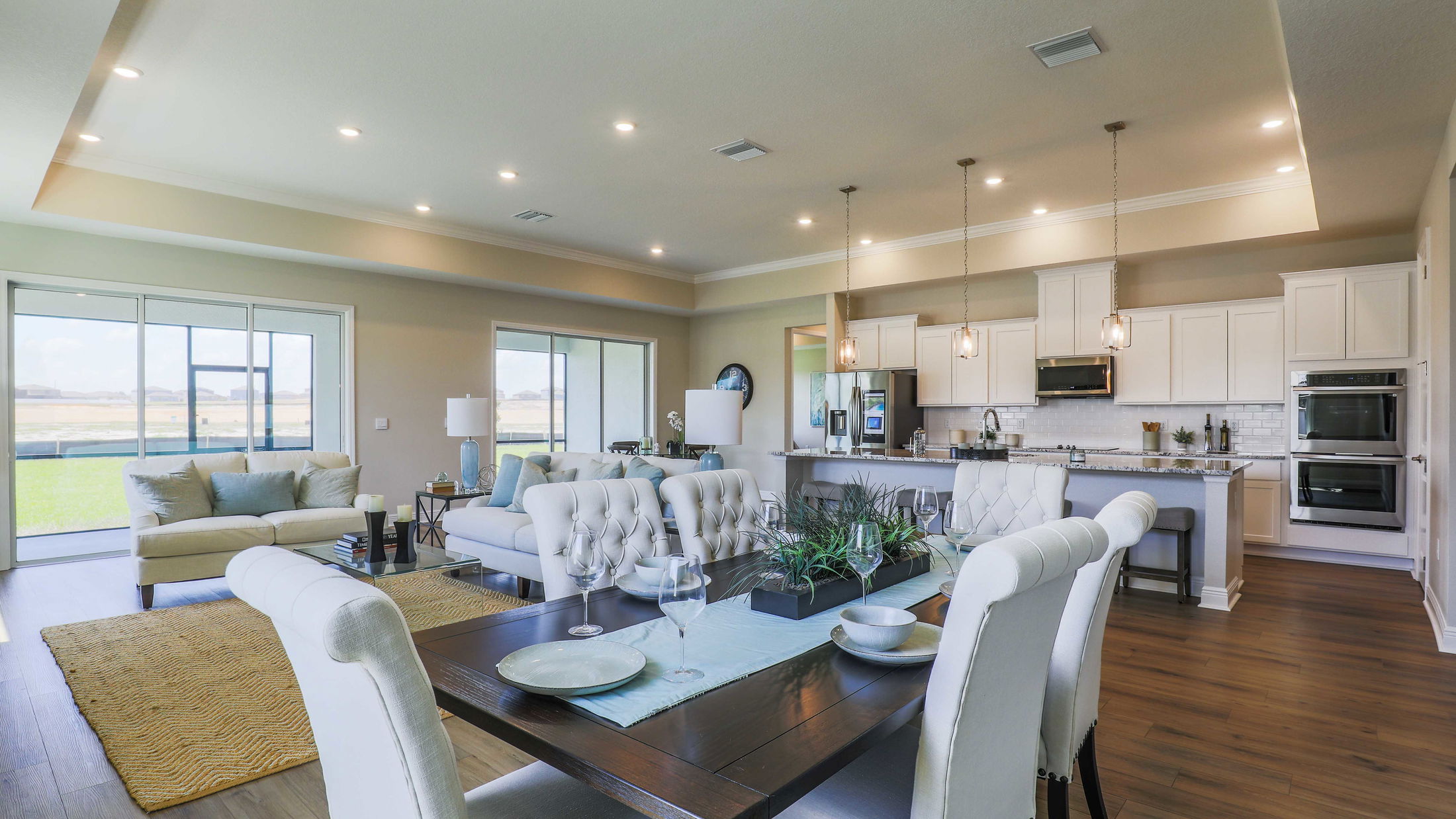 Modern open-concept living and dining area with stylish furniture, elegant lighting, and a spacious kitchen.