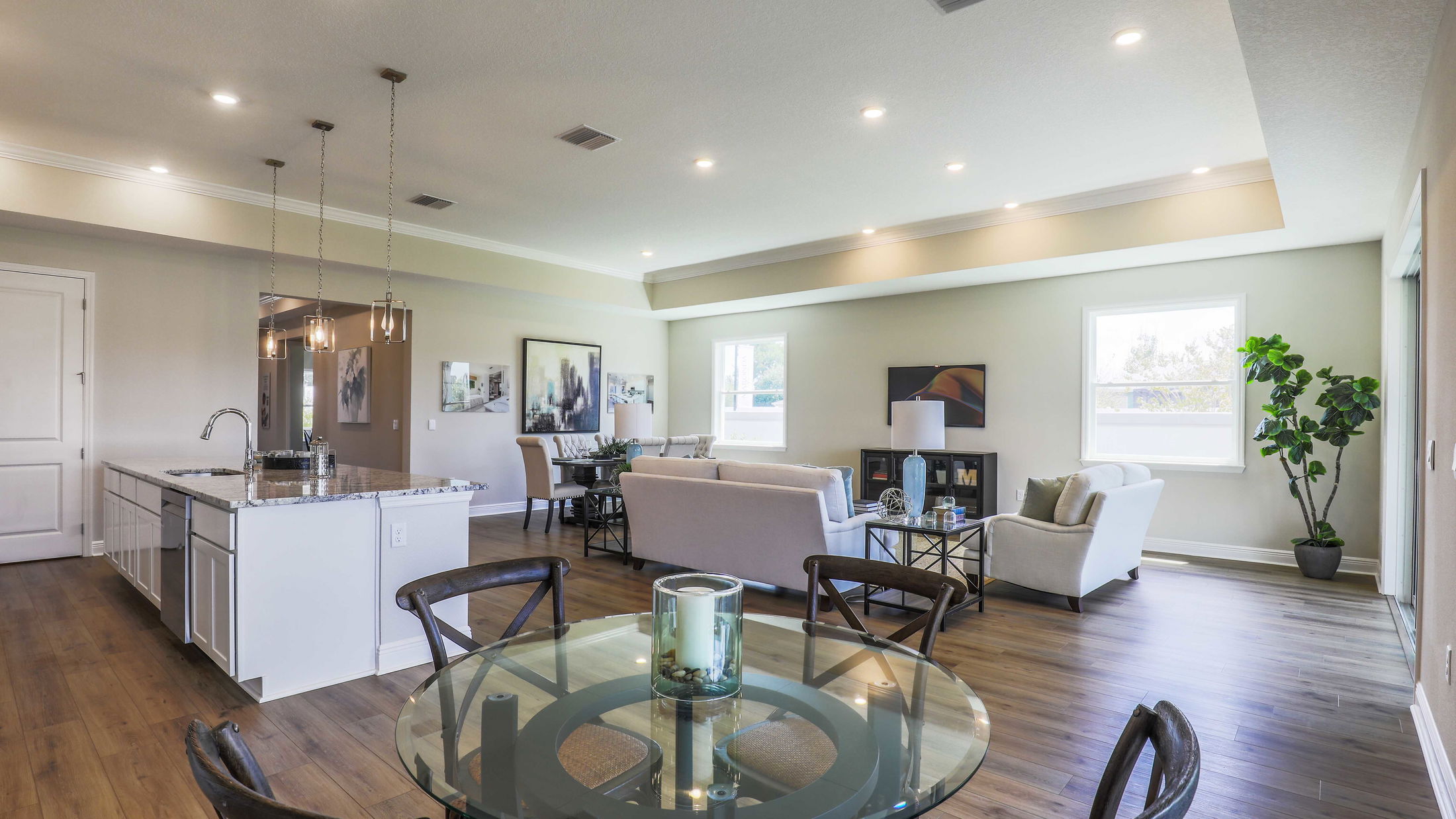 Modern open-concept living room and kitchen with elegant decor, hardwood floors, and abundant natural light.