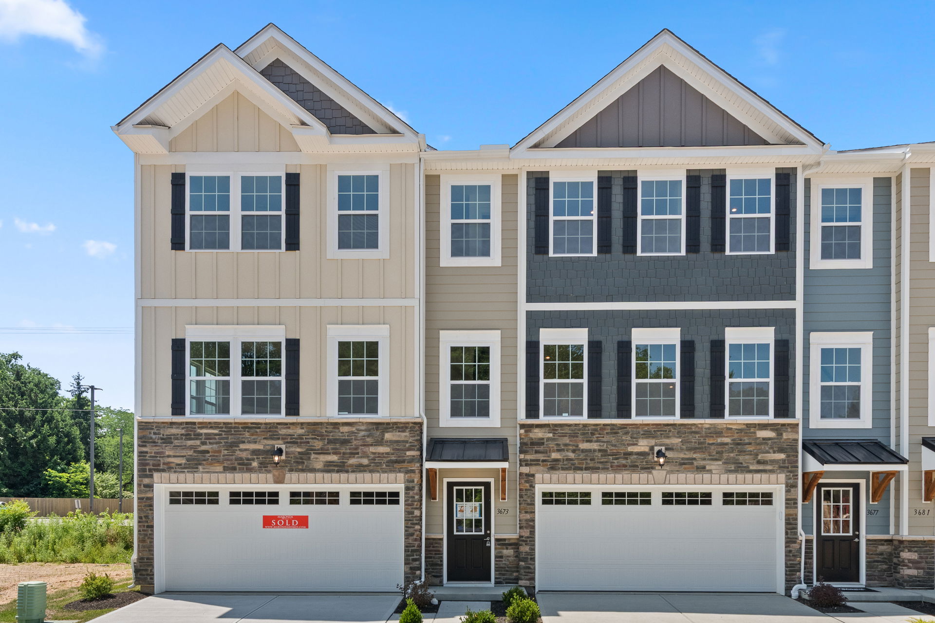 Modern townhouse with beige and grey exterior featuring a 