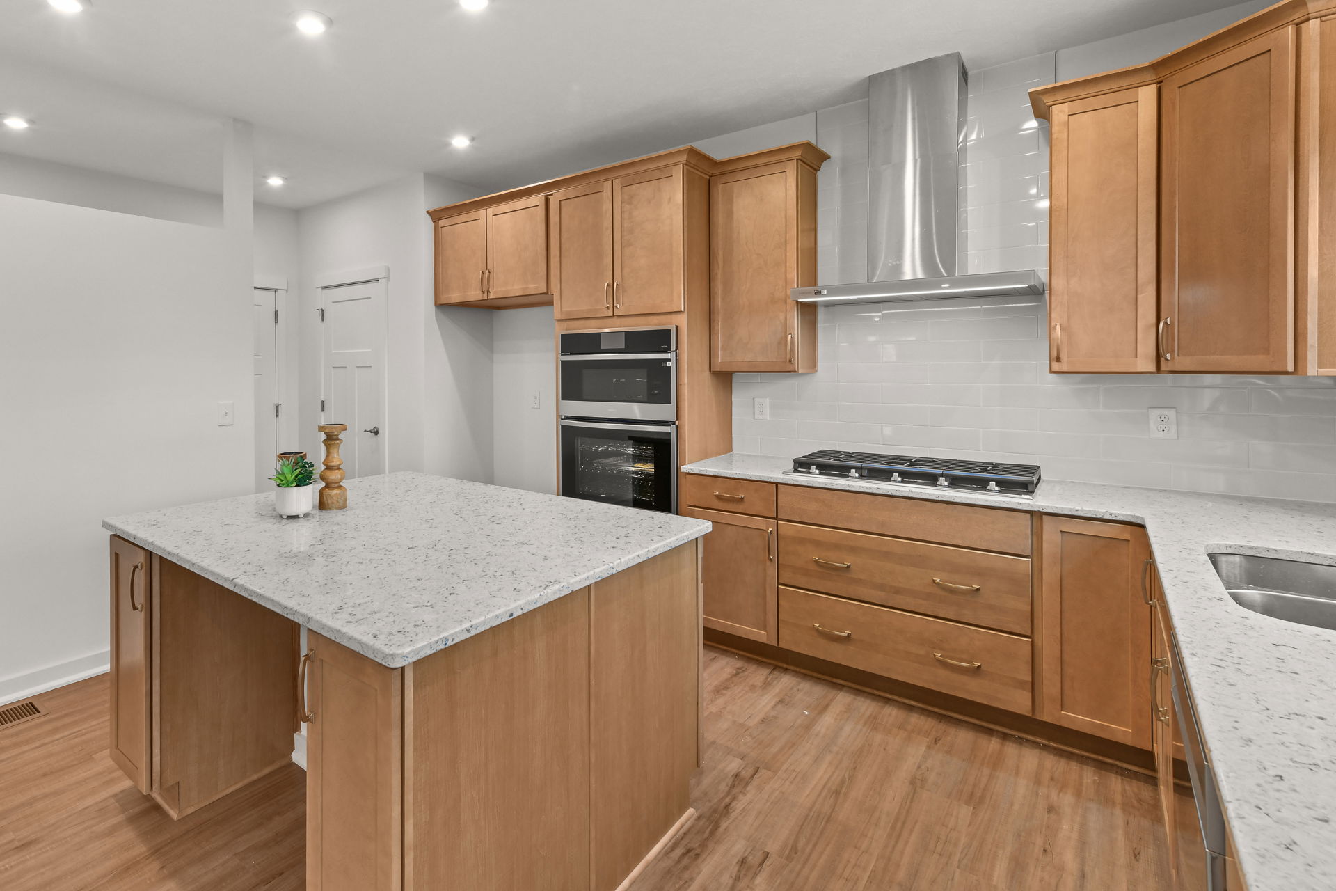 Modern kitchen design featuring wooden cabinets, a quartz countertop island, and stainless steel appliances.