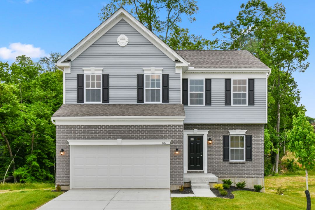 Modern two-story suburban home with gray siding, black shutters, and a double garage.