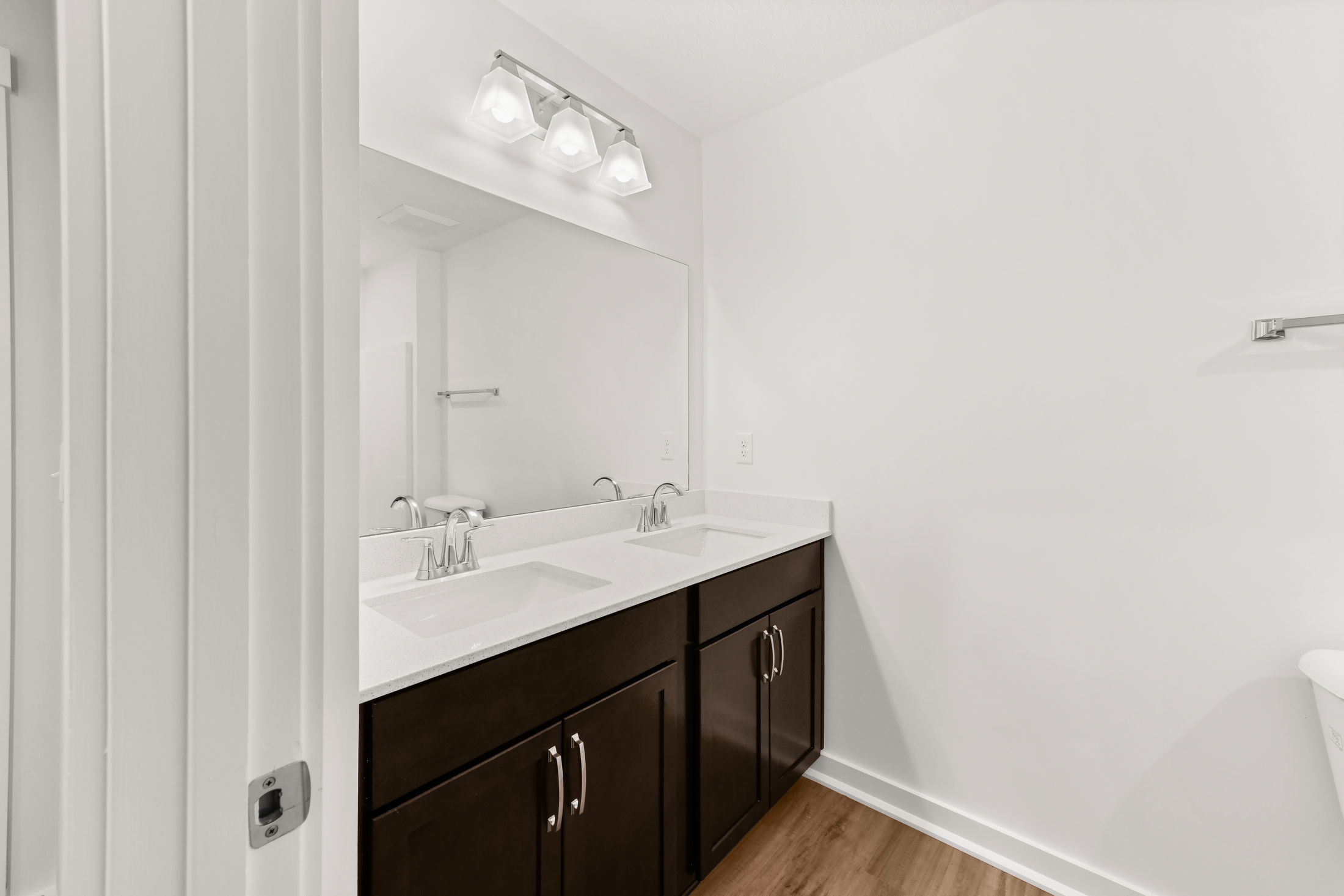 Modern bathroom with a double sink vanity, large mirror, and elegant lighting fixtures.