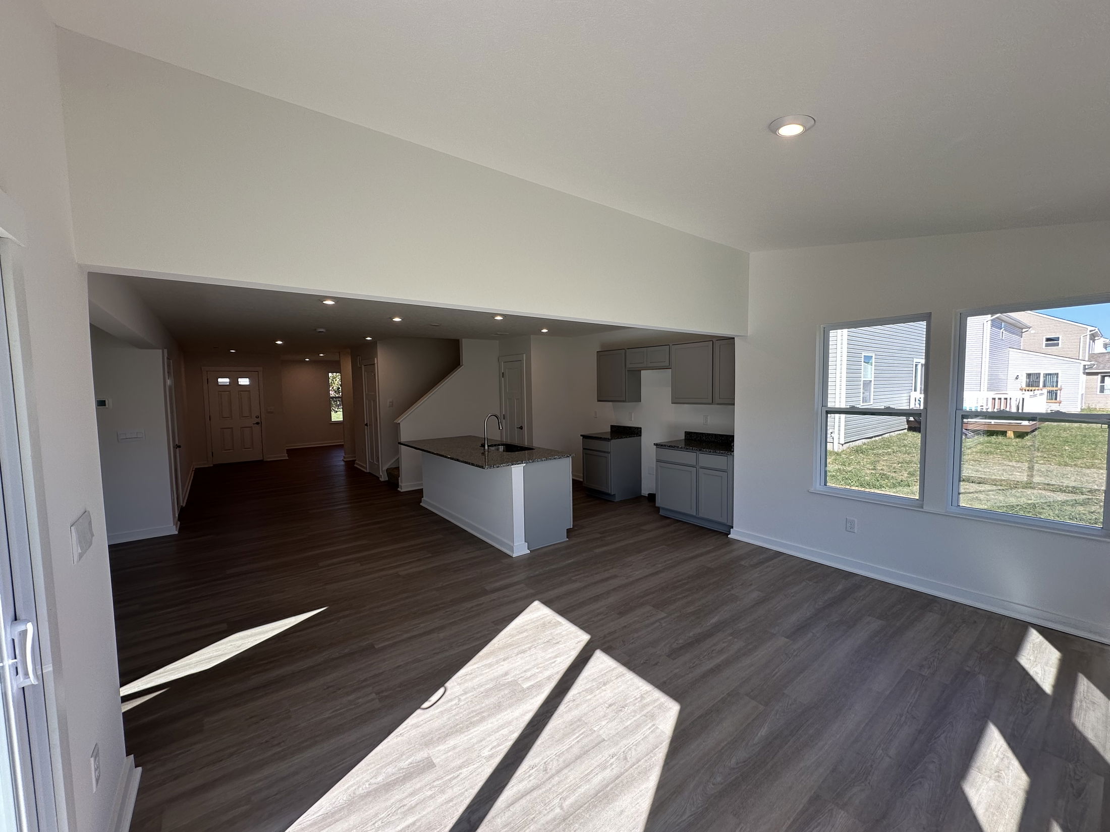 Bright and spacious open-concept living area with hardwood floors and modern kitchen in a new home.