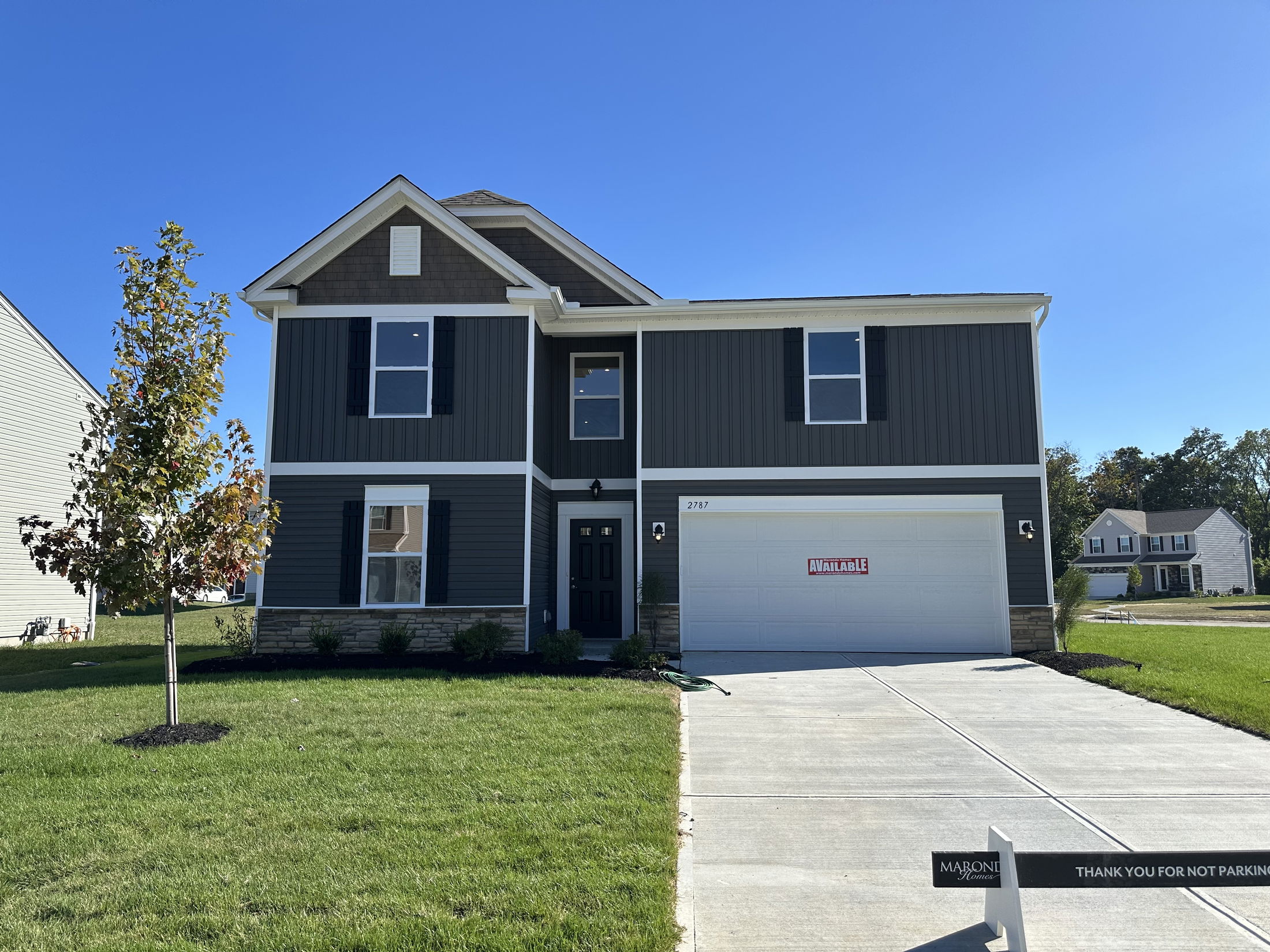 Modern two-story house with gray siding, landscaped yard, and an 