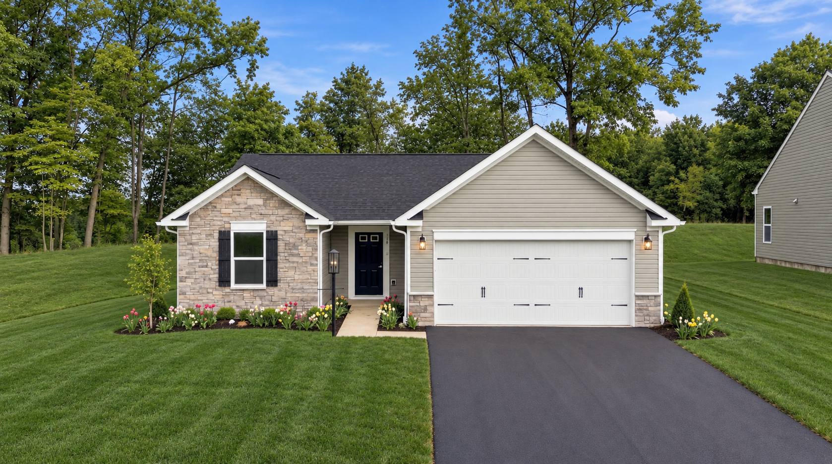 Single-story house with a stone and vinyl exterior, manicured lawn, and a driveway leading to a garage.