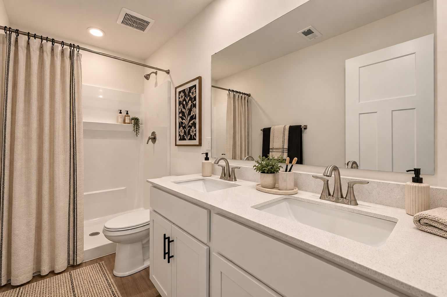 Modern bathroom with double sinks, white cabinetry, a shower area, and neutral decor.