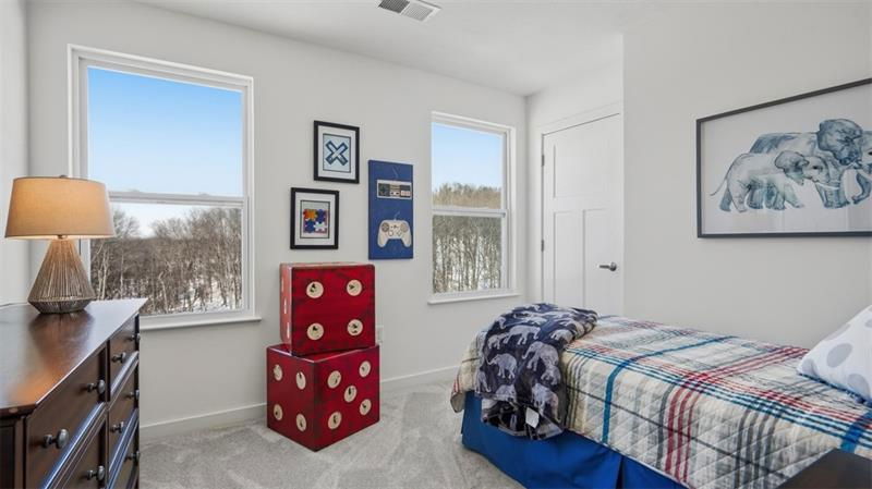Cozy children's bedroom featuring a single bed, playful decor, and a window view of nature.