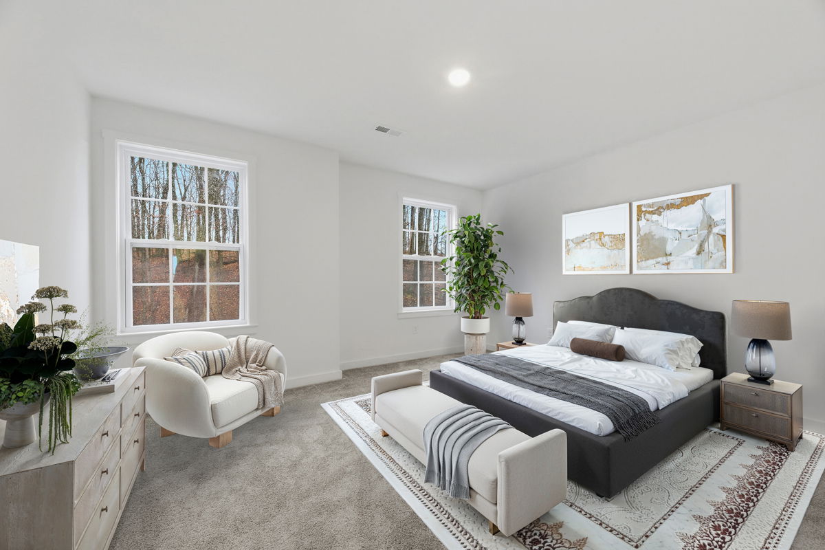Modern bedroom with large windows, neutral decor, and comfortable furniture including a bed, armchair, and potted plant.