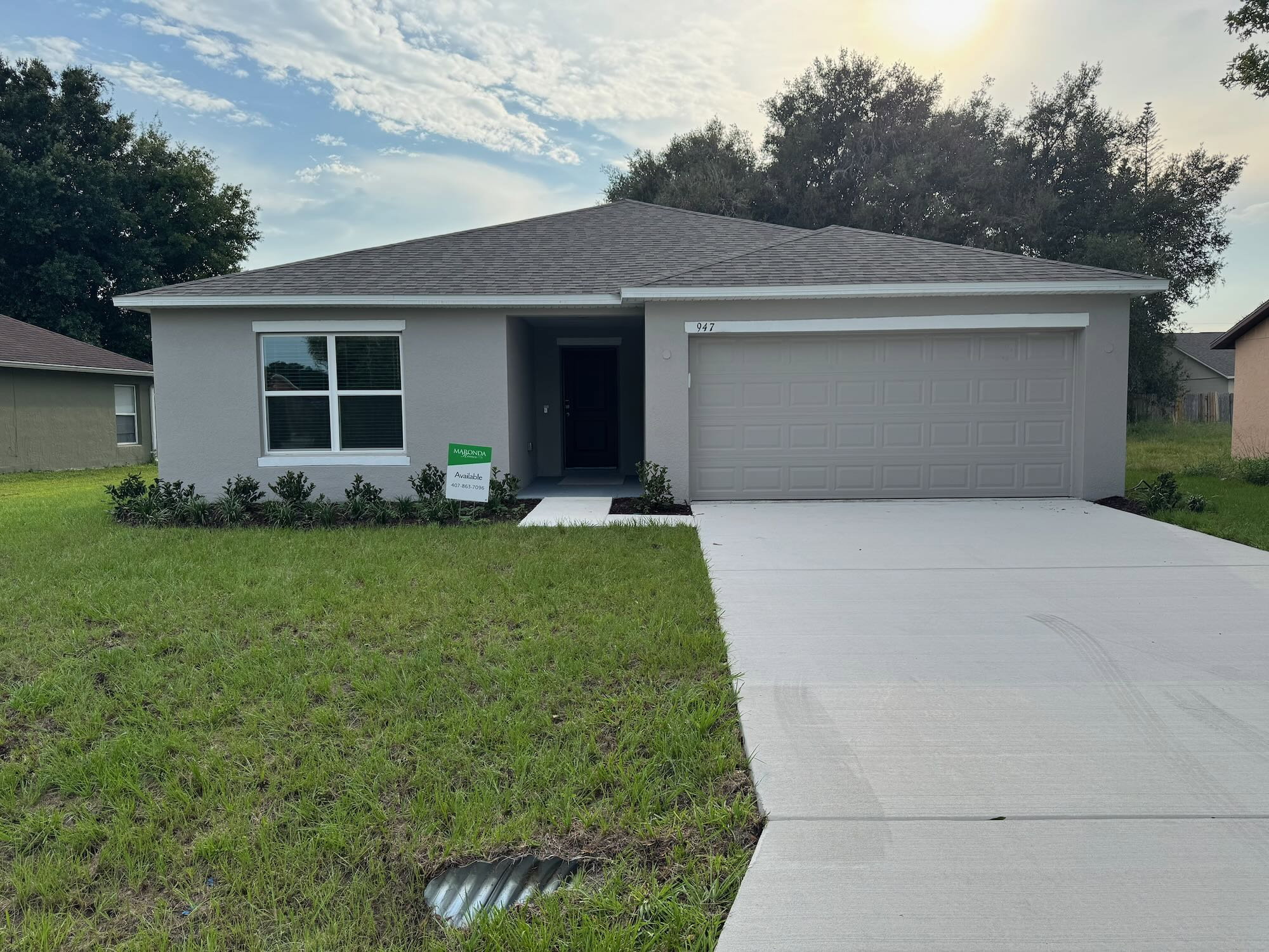 A single-story house with a gray exterior, a two-car garage, and a manicured lawn.