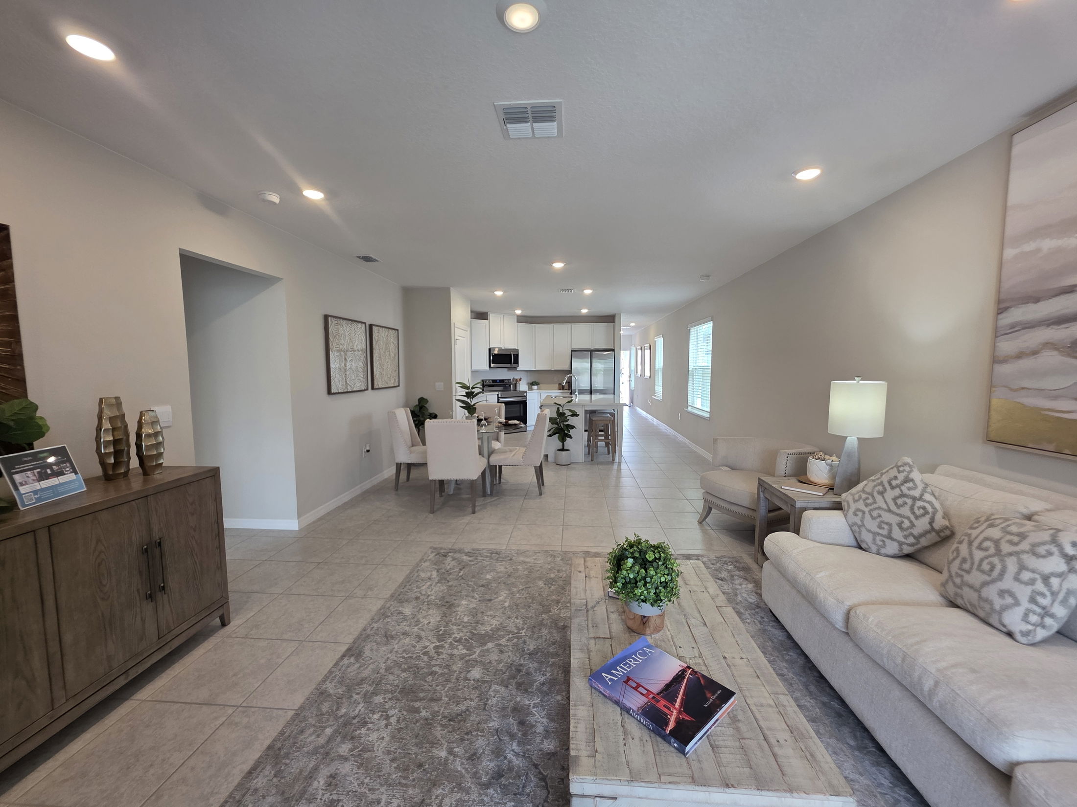 Spacious and modern living room interior featuring a light color scheme, comfortable seating, and stylish decor elements.
