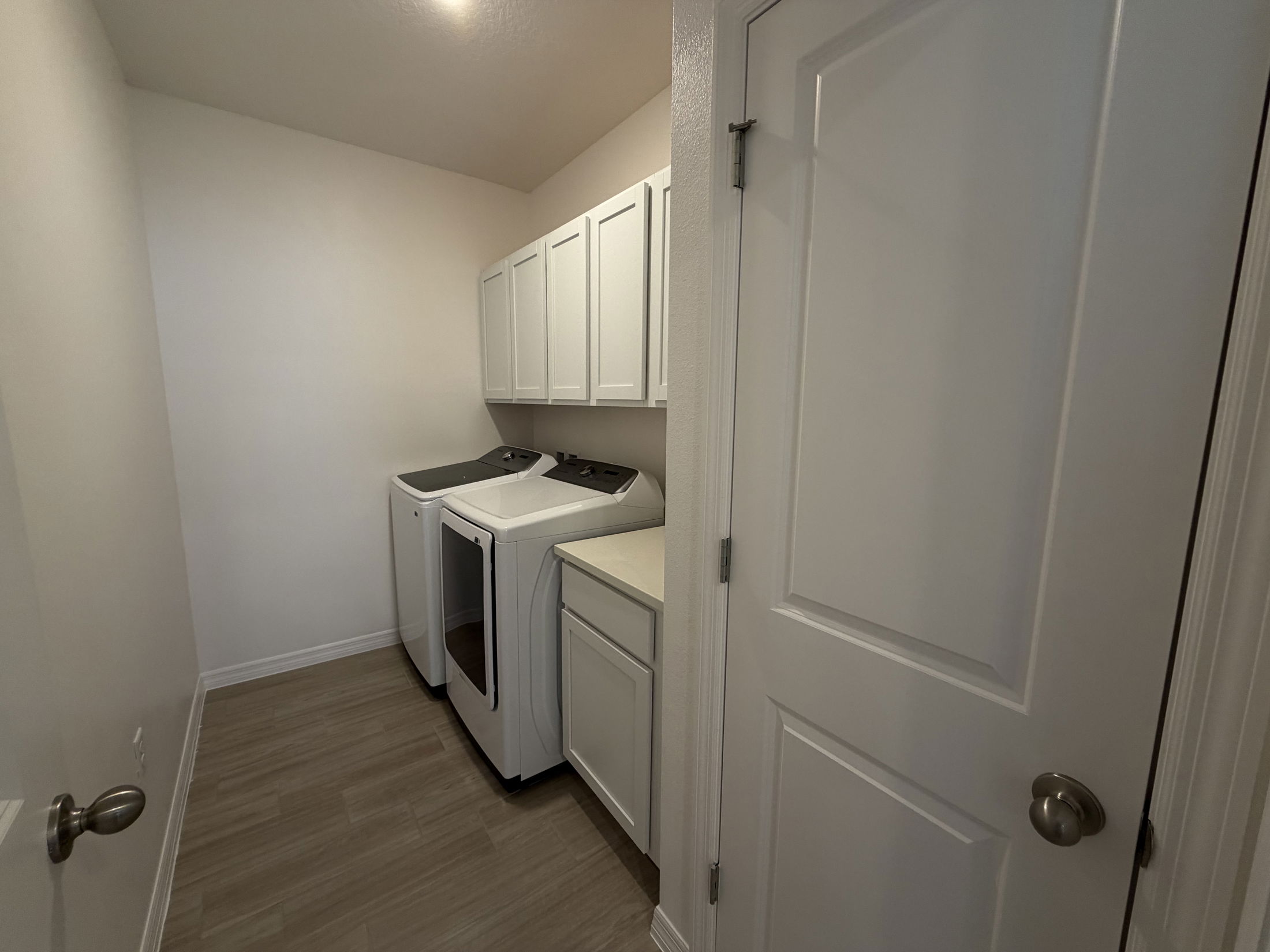Bright and spacious laundry room with modern appliances and ample storage cabinets.