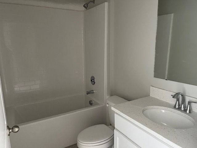 Modern, minimalist bathroom featuring a white bathtub, sleek sink, and simple fixtures.