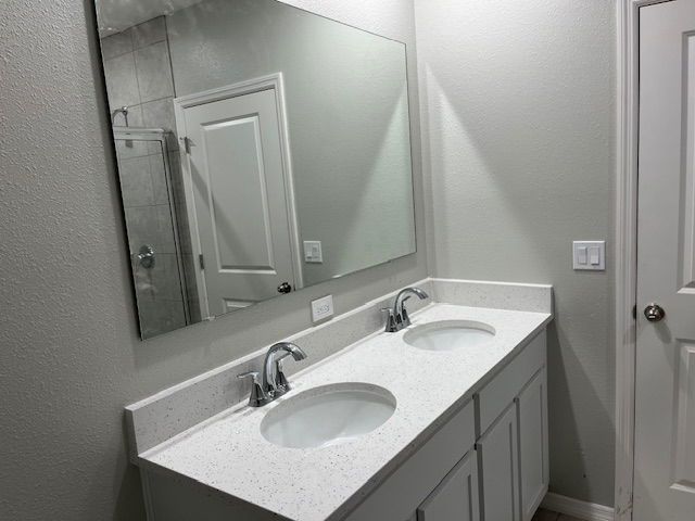 Modern bathroom with double vanity and large mirror featuring white cabinets and polished fixtures.