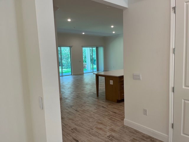 Open-concept living area with wood flooring, sliding glass doors, and a kitchen island in a modern home.