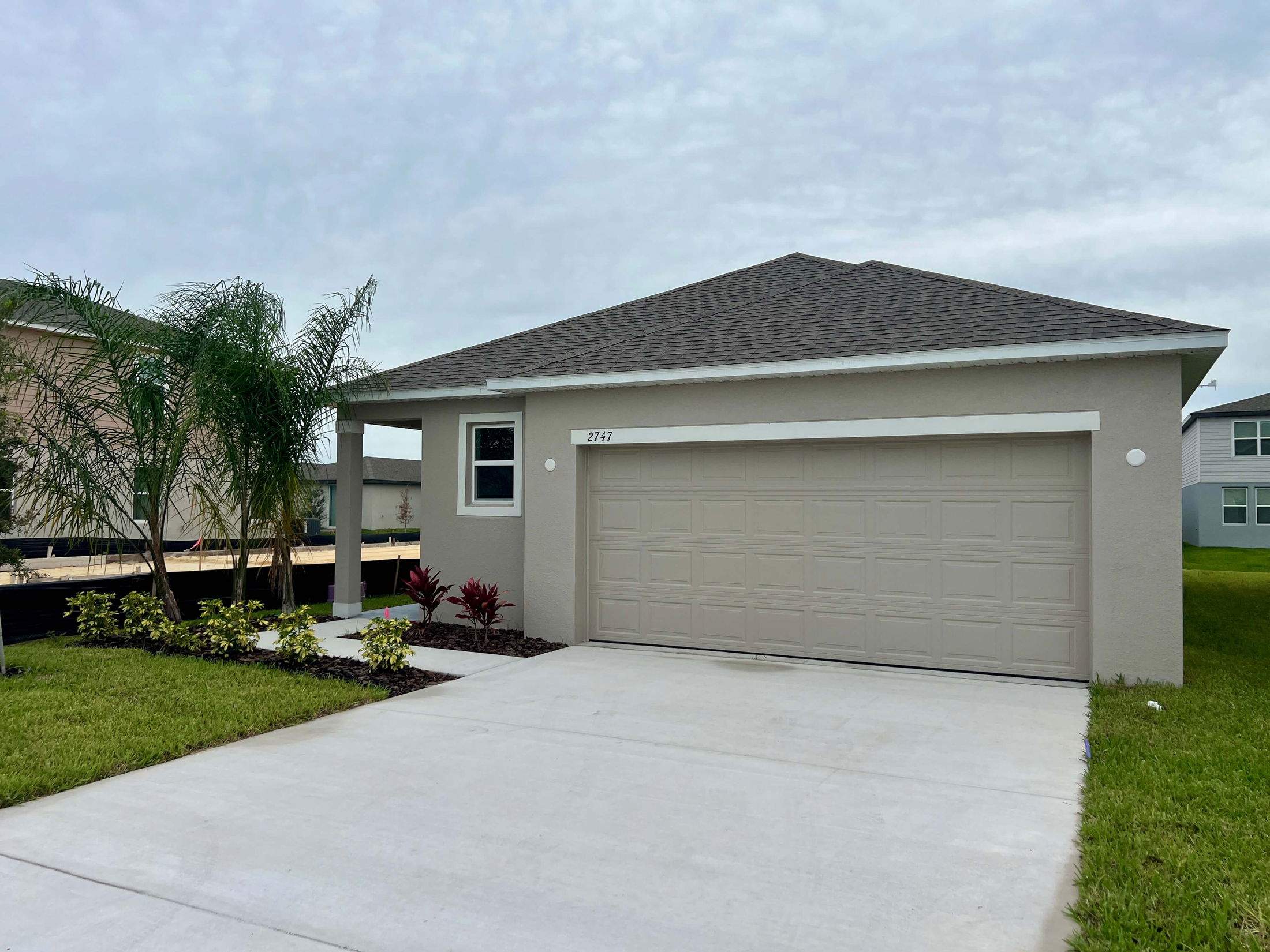 Modern single-story home with a two-car garage and neatly landscaped front yard.