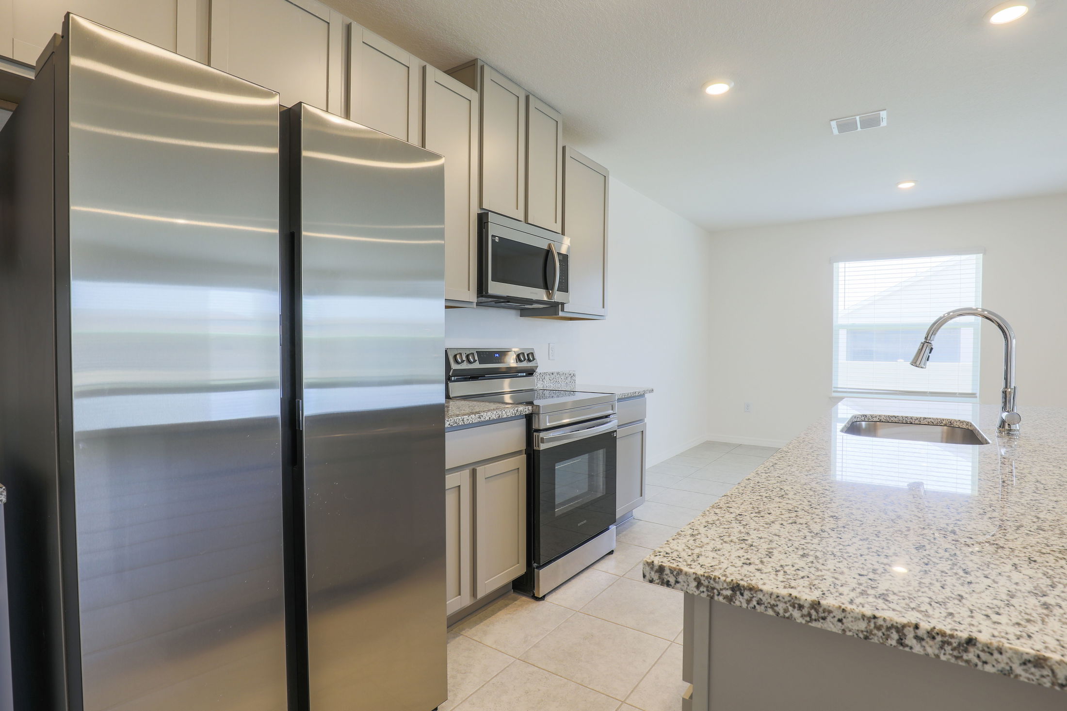 Modern kitchen with stainless steel appliances, granite countertops, and a spacious island.