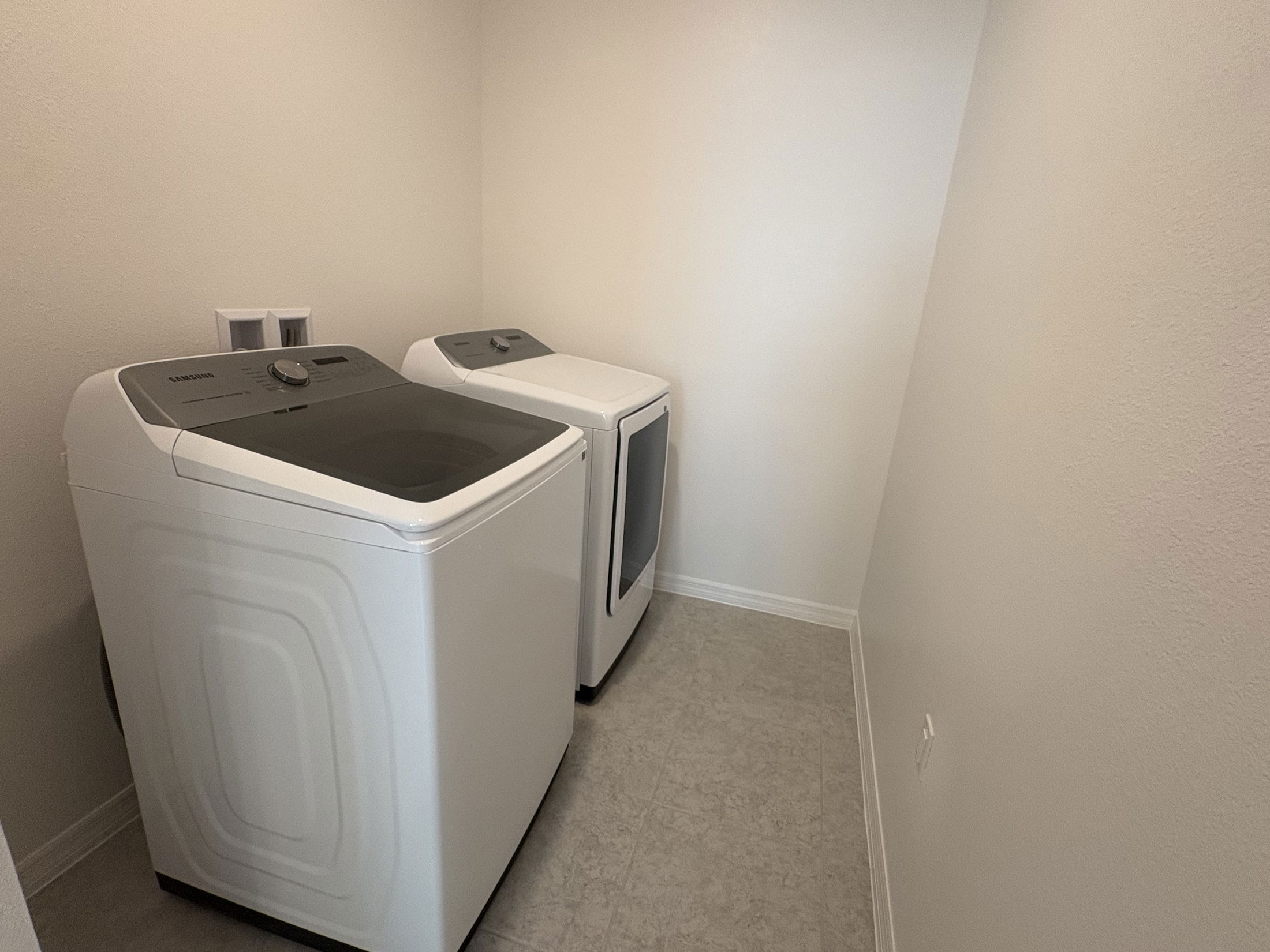 Modern laundry room with Samsung washer and dryer set against a neutral wall.