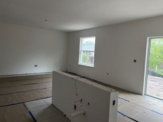 Partially completed room showing interior construction with drywall and taped floors.