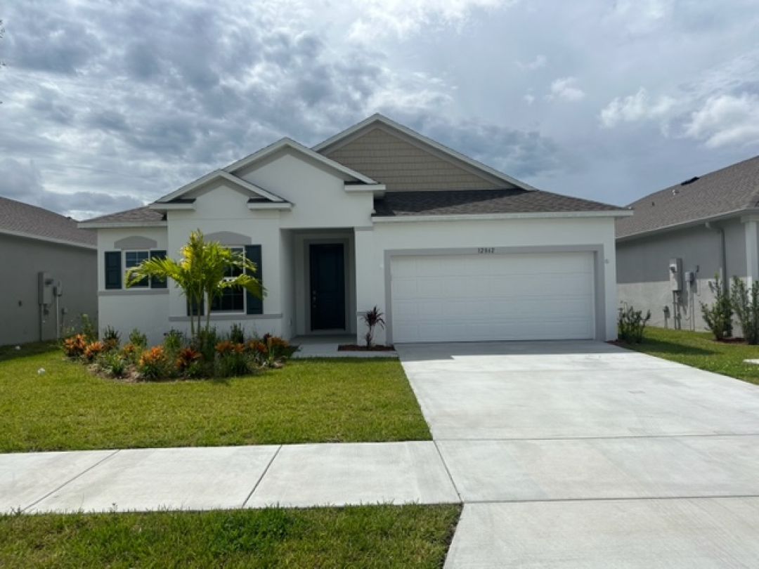 Single-story modern house with a neatly landscaped front yard and a two-car garage.