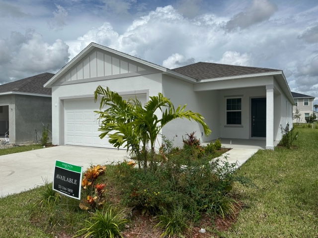 Single-story modern white house with attached garage, landscaped front yard, and 