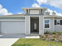Modern single-story home with a light gray exterior and a covered entrance under a porch.
