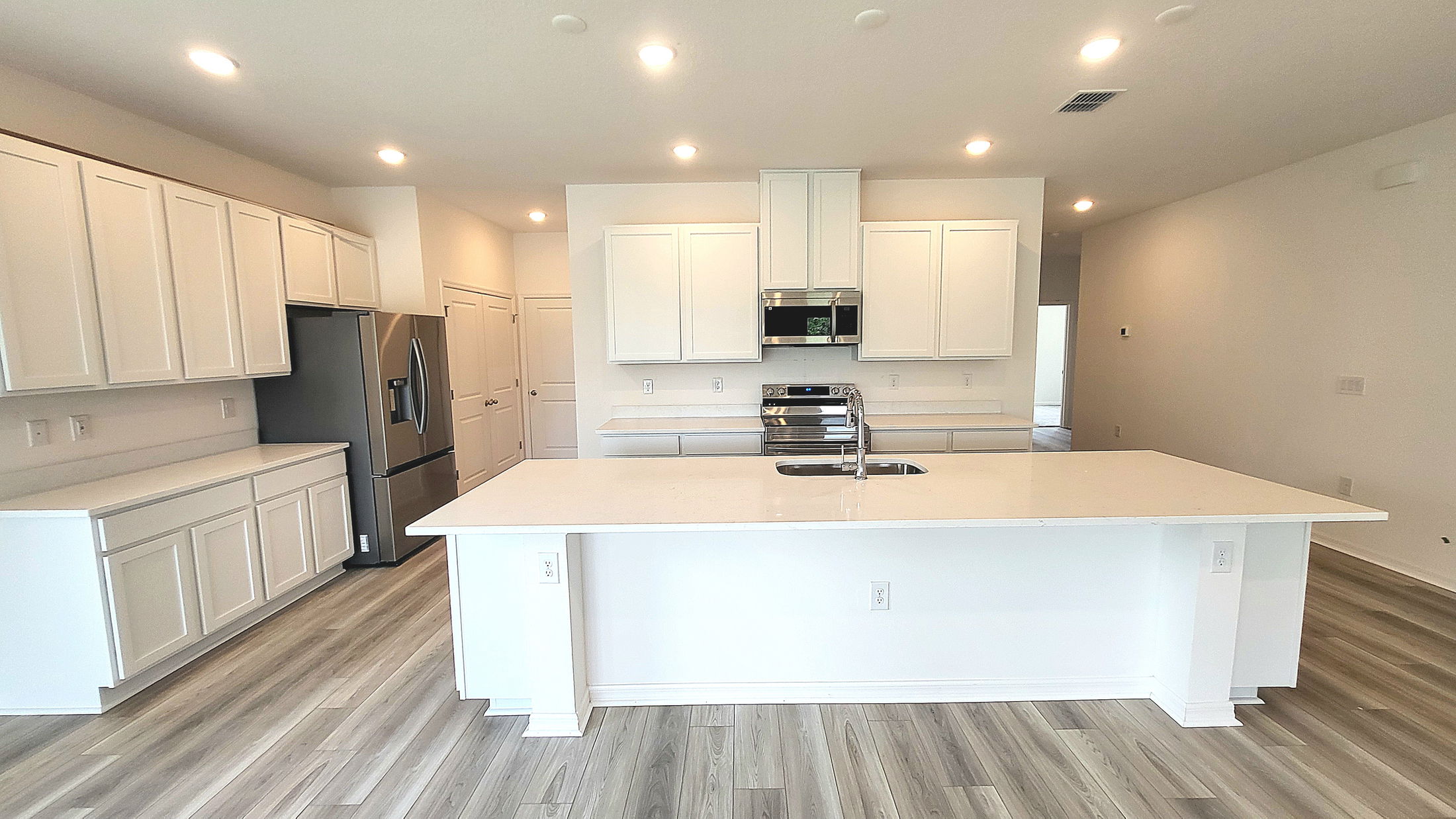 Modern kitchen with white cabinets, stainless steel appliances, and a sleek island.