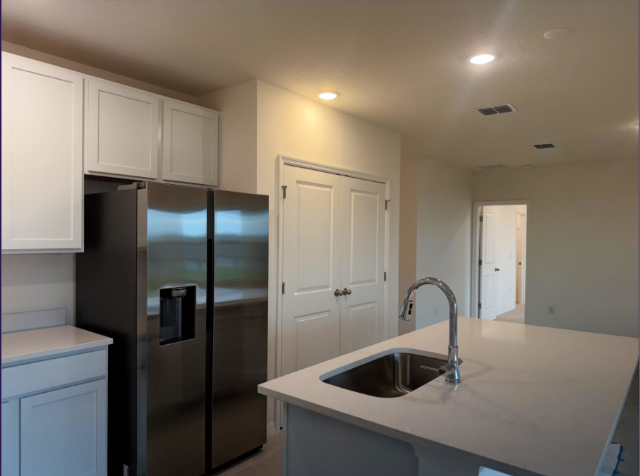 Modern kitchen featuring stainless steel appliances, white cabinetry, and a central island with a sink.