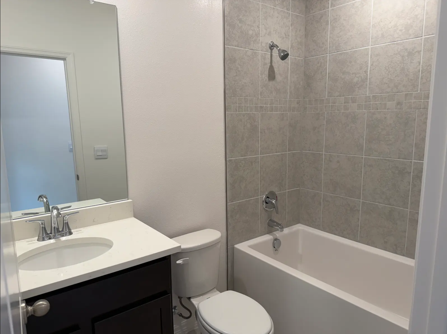 Modern bathroom featuring a bathtub, shower, toilet, and sink with a vanity.