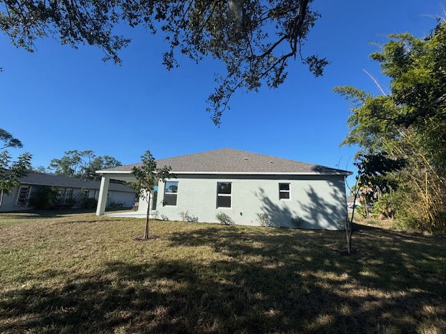 Exterior view of a modern one-story house with a landscaped yard under a clear blue sky.