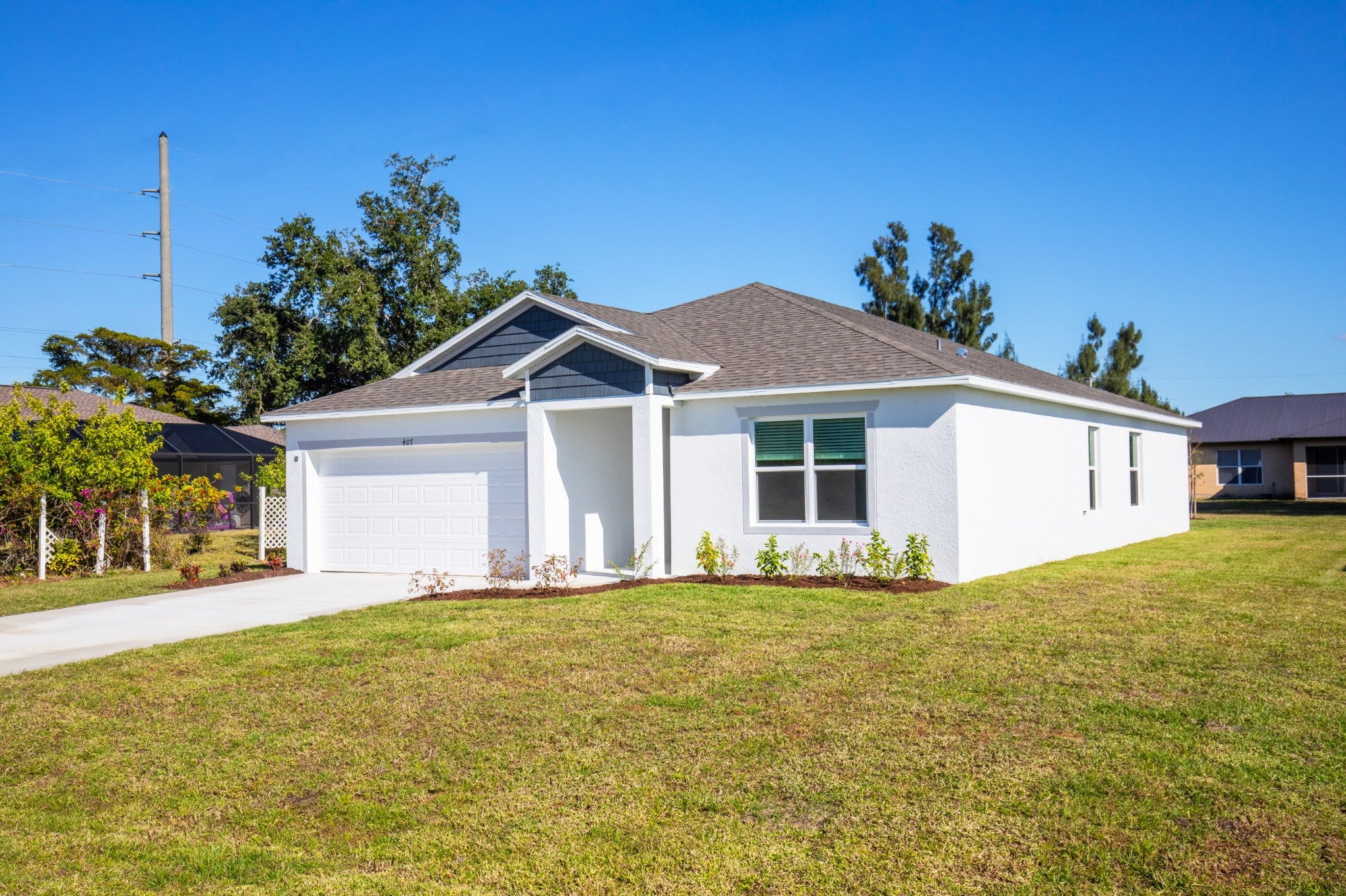 Front view of a modern single-family home with a well-maintained lawn and clear blue sky.