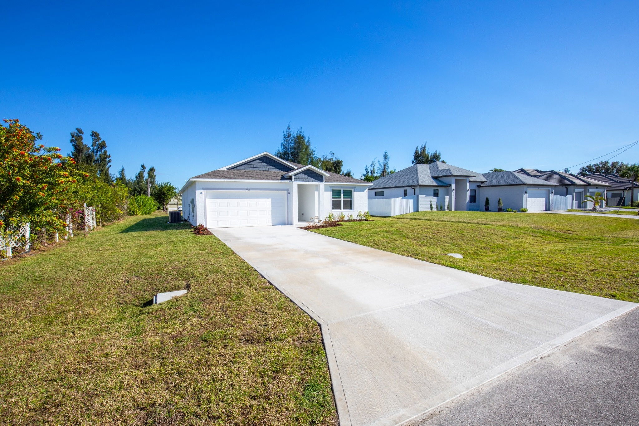 Modern single-family home with a spacious driveway and manicured lawn in a suburban neighborhood.