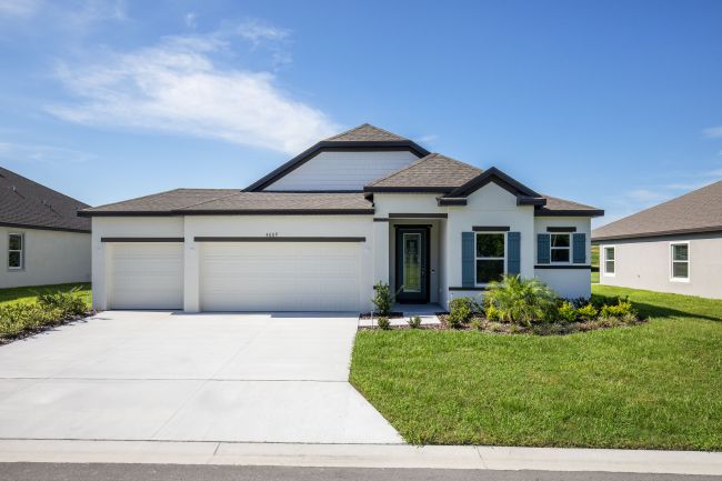 Modern single-story house with a three-car garage, manicured lawn, and blue sky background.
