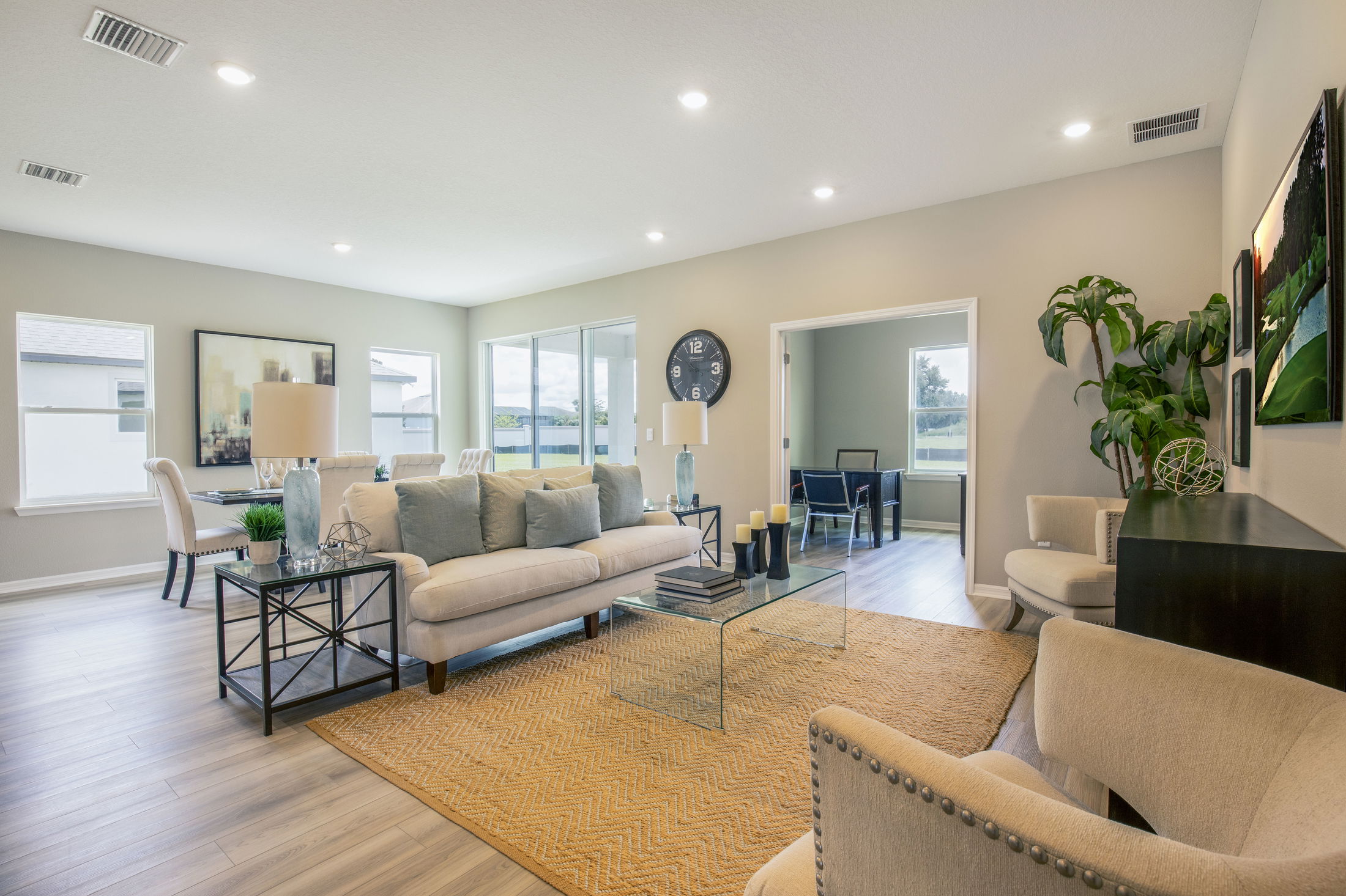 Modern living room with neutral tones, elegant furnishings, and large windows showcasing natural light.