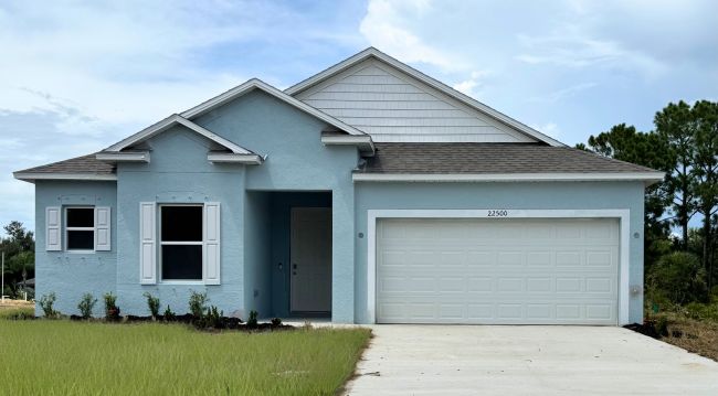 Single-story blue house with a two-car garage, white trim, and a neatly landscaped front yard.